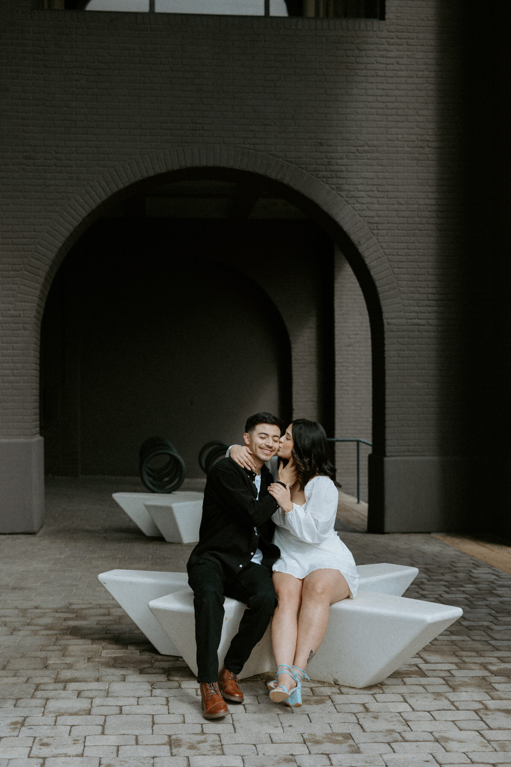 downtown couple photoshoot women kissing man on cheek
